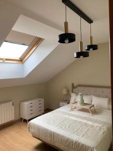 a bedroom with a large bed and a skylight at Alojamiento fiordos leoneses Boñar in Boñar
