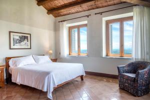 una camera da letto con un letto, una sedia e finestre di Hotel Monteconero a Sirolo