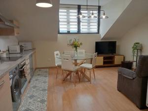 a kitchen and living room with a table and chairs at Alojamiento fiordos leoneses Boñar in Boñar