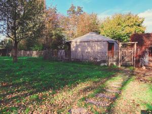 a gazebo in a yard next to a fence at La yourte du verger d Hellebecq in Silly
