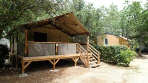 a cabin with a porch in front of a house at Domaine Les Chênes Blancs in Saint-Saturnin-lès-Apt