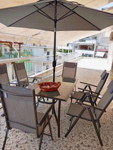 a table and chairs with an umbrella on a patio at Kavala Penthouse in Kavala