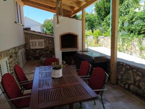 eine Terrasse mit einem Tisch, Stühlen und einem Kamin in der Unterkunft Blue Paradise Apartman 2 in Sevid