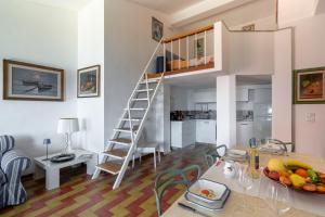 a kitchen and living room with a spiral staircase in a apartment at Argentarola in Porto Santo Stefano,Pool and Sea View in Porto Santo Stefano