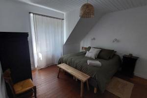 a bedroom with a bed and a bench in it at La Maison de Roz-Ar-Floc'h in Audierne