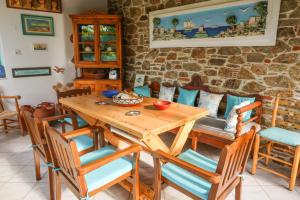 a dining room with a wooden table and chairs at Studios Villa Eleni in Skiathos Town
