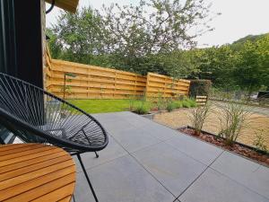 a patio with a bench and a wooden fence at AMIKALEMENT VÔTRE - Gîte 2 personnes in La-Roche-en-Ardenne