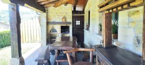 a porch with a wooden table and two chairs at Villa DOLARETXE in Barroeta