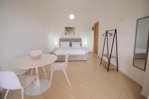 a bedroom with a bed and a table and chairs at Nefeli's Apartment in Himare