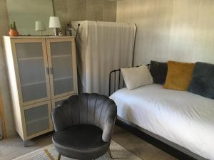 une chambre avec un lit et une chaise dans l'établissement Au calme, proche gare, à Brive-la-Gaillarde