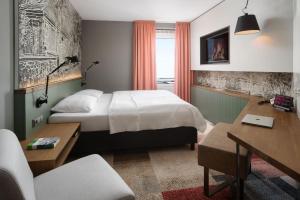 a hotel room with a bed and a desk at Hotel FREIZEIT IN in Göttingen