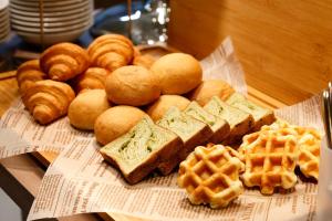 a plate of bread and waffles and waffleergy at Dormy Inn Nagano in Nagano