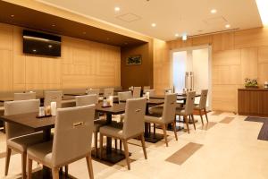 a large dining room with tables and chairs at Dormy Inn Nagano in Nagano