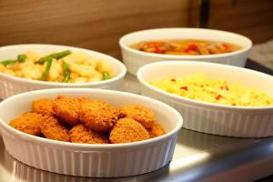 four white bowls of food on a table at Dormy Inn Nagano in Nagano