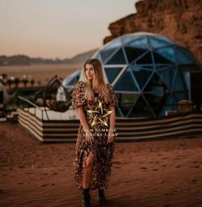 a woman in a dress standing in the desert at RUM SUNRlSE LUXURY CAMP in Wadi Rum