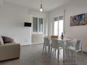 a white dining room with a white table and chairs at Casa Vacanze CuprAmare in Cupra Marittima