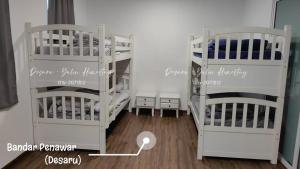 a room with three bunk beds in a room at Desaru Yulin Homestay 雨林客棧Desaru, Bandar Penawar in Bandar Penawar +4 photos