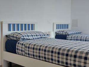 two beds sitting next to each other in a room at Casa Vacanze CuprAmare in Cupra Marittima