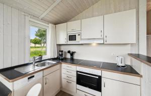 a kitchen with white cabinets and a sink and a window at Friedrichskoog-Deichblick 16 in Friedrichskoog