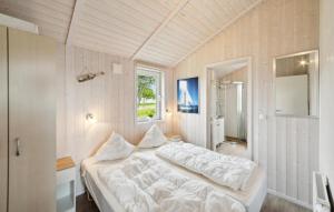 a bedroom with a white bed and a window at Friedrichskoog-Deichblick 16 in Friedrichskoog +11 photos