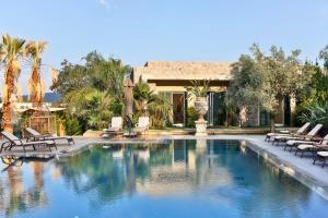 a swimming pool with lounge chairs and a house at Bella Sombra Hotel in Golturkbuku
