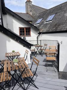 a patio with tables and chairs on a building at The Swan in Bampton