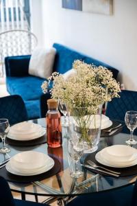 einen Tisch mit Platten und eine Vase Blumen darauf in der Unterkunft Modern City Centre 2 Bed Apt in Leeds & Netflix & Hammock in Leeds