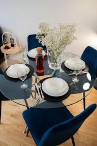 ein Glastisch mit Tellern und Weingläsern darauf in der Unterkunft Modern City Centre 2 Bed Apt in Leeds & Netflix & Hammock in Leeds + 22 Fotos