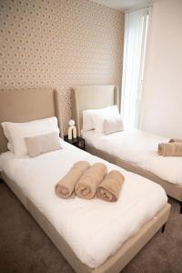 ein Schlafzimmer mit zwei Betten mit Handtüchern darauf in der Unterkunft Modern City Centre 2 Bed Apt in Leeds & Netflix & Hammock in Leeds