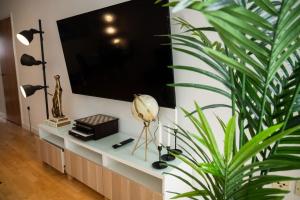 ein Wohnzimmer mit einem TV und einer Anlage in der Unterkunft Modern City Centre 2 Bed Apt in Leeds & Netflix & Hammock in Leeds