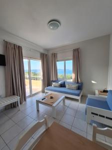 a living room with a blue couch and a table at Artemis Apartments in Kalyves