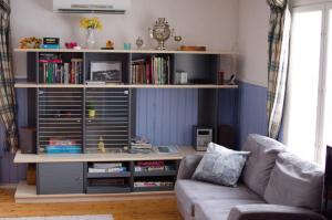 un soggiorno con libreria e divano di Sänkelä Cottage a Lämsä