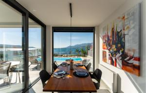 a dining room with a table and views of a pool at Beautiful Apartment In Rovanjska in Rovanjska