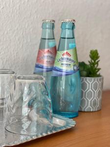 zwei Flaschen Wasser und Gläser auf dem Tisch in der Unterkunft Hotel zur Eiche in Meerane