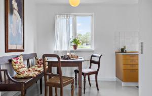 a dining room with a table and chairs and a window at 1 Bedroom Cozy Home In Nykøbing M in Flade