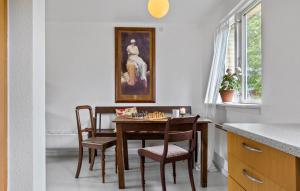 a dining room with a table and chairs and a painting at 1 Bedroom Cozy Home In Nykøbing M in Flade