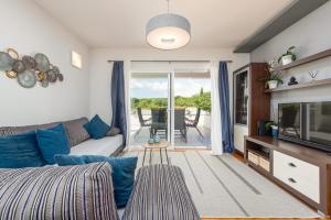 Una sala de estar con un sofá y un televisor. en Villa Zeleni gaj ZadarVillas, en Donje Raštane