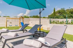 un patio con sillas, una sombrilla y un columpio en Villa Zeleni gaj ZadarVillas, en Donje Raštane