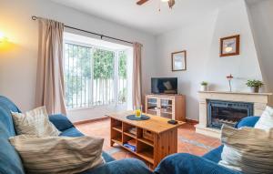 a living room with a blue couch and a fireplace at Lovely Home In Chiclana De La Fronter in Chiclana de la Frontera