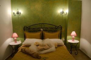a bedroom with a bed with two lamps on both sides at Angel Cave Houses in Oia