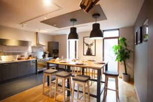a kitchen with a large wooden table and stools at Au Cerf & Fagnes in Spa