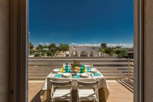 ein Tisch mit Stühlen auf einem Balkon in der Unterkunft Villa Edera by BarbarHouse in Marina di Lizzano