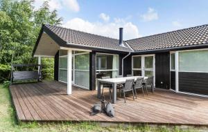 a house with a wooden deck with a table and chairs at Stunning Home In Gilleleje With Sauna in Gilleleje +14 photos