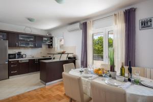 eine Küche und ein Esszimmer mit Tisch und Stühlen in der Unterkunft Sunshine Holiday Home in Kaštela