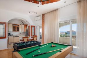 ein Wohnzimmer mit einem Billardtisch und eine Küche in der Unterkunft Sunshine Holiday Home in Kaštela
