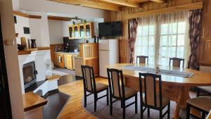 a kitchen and dining room with a table and chairs at Casa Amalia Tocile -Sadu in Sadu