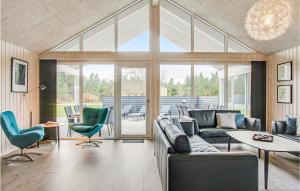 salon z kanapą, stołem i krzesłami w obiekcie Cozy Home In Blåvand With Wifi w mieście Blåvand