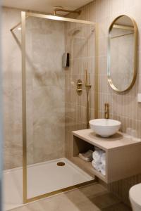 a bathroom with a shower with a sink and a mirror at Hotel Restaurant Belv&eacute;d&egrave;re in Schoonhoven