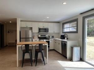 a kitchen with a table and two bar stools at East Rock Inn in Great Barrington
