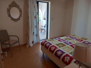 Un dormitorio con una cama, una silla y un espejo. en Mary House, en Pefkali